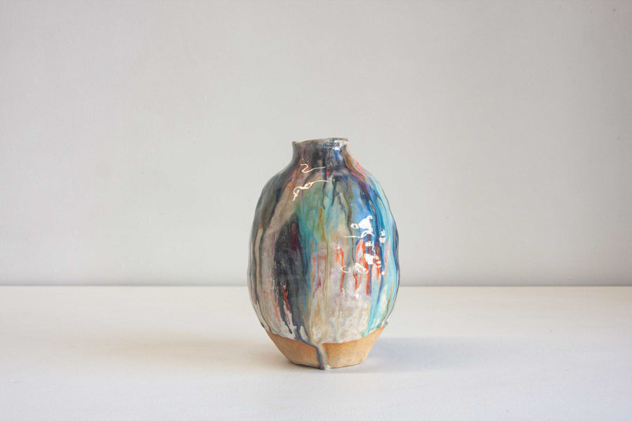 handmade ceramic vase glazed in orange, blue. brown and white.