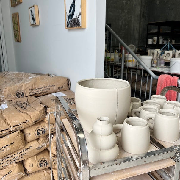 freshly slipcasted pieces drying next to a pile of slip casting clay powder