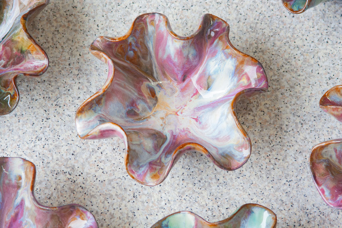 frilly oyster shaped black clay ceramic bowl glazed in pinks and creams