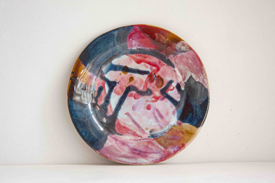 Handmade ceramic dinner plate glazed in reds, blues, whites and brown.