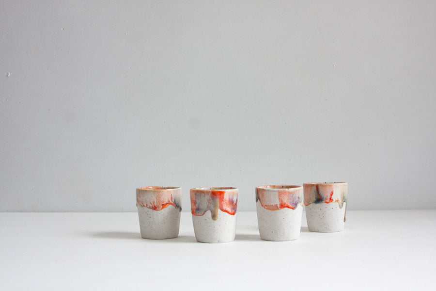 handmade ceramic espresso cup glazed in orange, brown and blue
