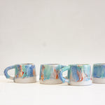 four handmade ceramic mugs on top of a table