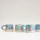 four handmade ceramic mugs on top of a table