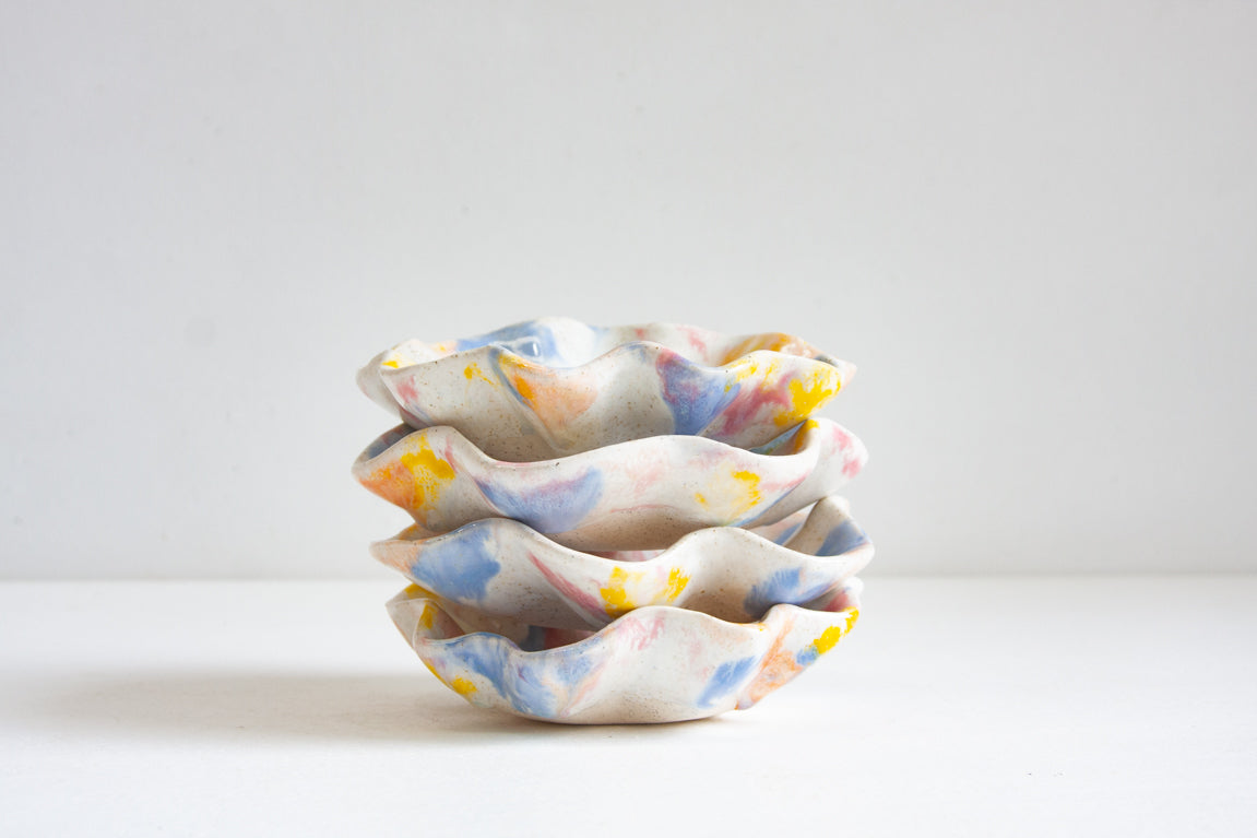 handmade ceramic oyster shaped plate glazed in yellow, blue, pink and peach