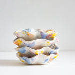 handmade ceramic oyster shaped plate glazed in yellow, blue, pink and peach