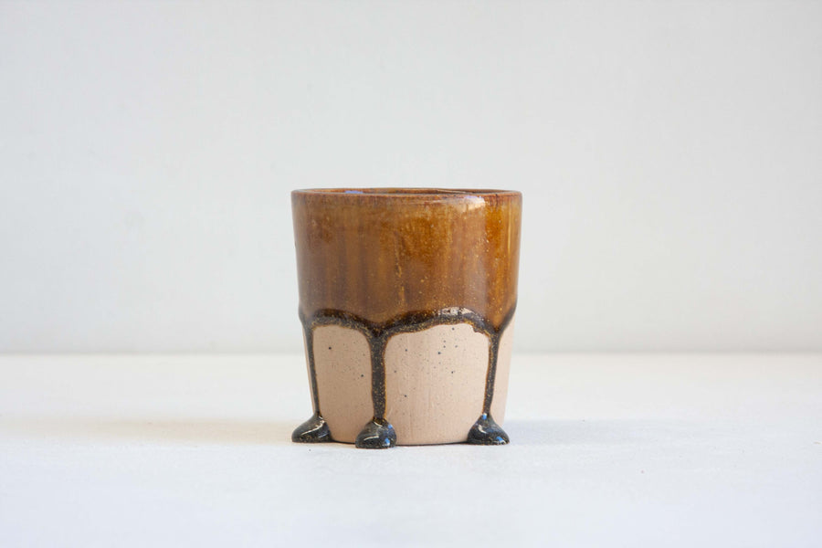 Handmade ceramic tumbler cup glazed in a drippy brown glaze.