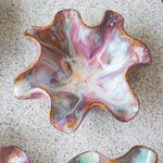 handmade ceramic dark clay oyster shaped wavy bowl glazed in pinks.