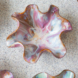 handmade ceramic dark clay oyster shaped wavy bowl glazed in pinks.