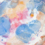 Top-down interior view of a handmade ceramic deep plate with soft blue, pink, peach and amber paint-pour glaze on a white base