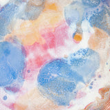 Top-down interior view of a handmade ceramic deep plate with soft blue, pink, peach and amber paint-pour glaze on a white base