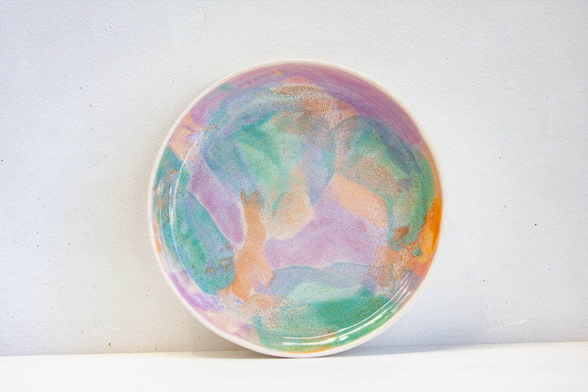 handmade deep ceramic plate glazed in purple, peach and green.