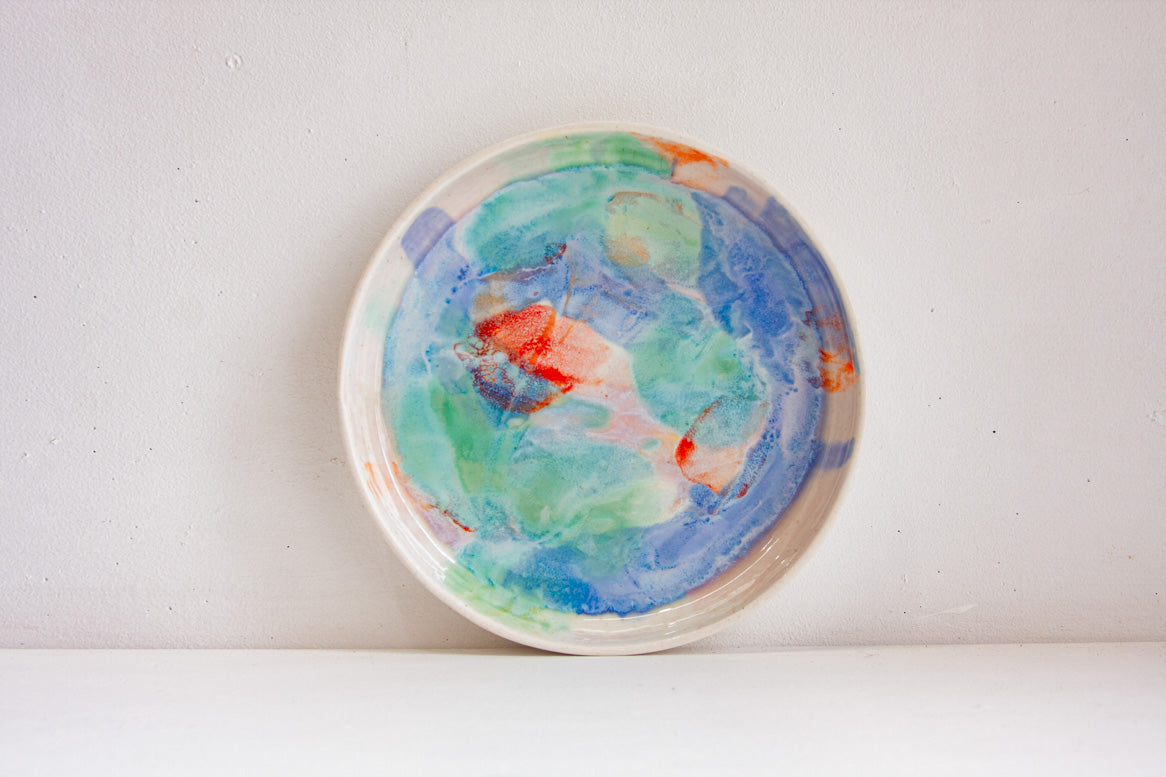 handmade ceramic deep plate glazed in blue, green, light purple and orange