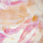 Extreme close-up of the interior of a handmade ceramic deep plate showing swirling soft pink, peach, amber and white paint-pour glaze detail