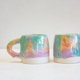 photo of two of handmade ceramic purple, green and peach large mugs