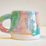 Close up of handmade single ceramic purple, green and peach large mug.