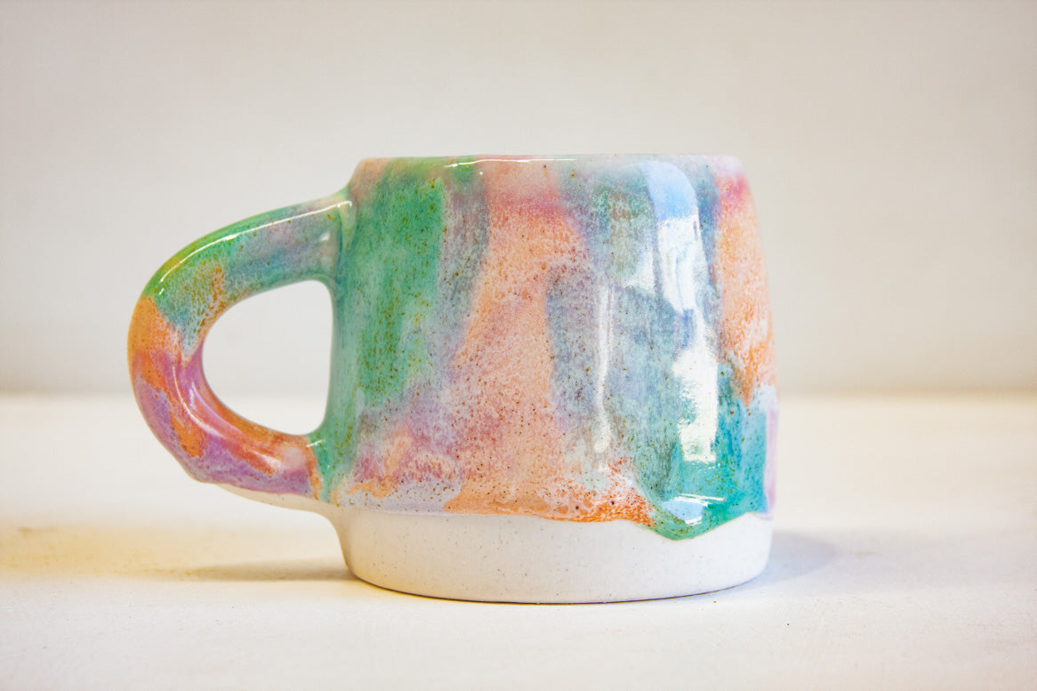 Close up of handmade single ceramic purple, green and peach large mug.
