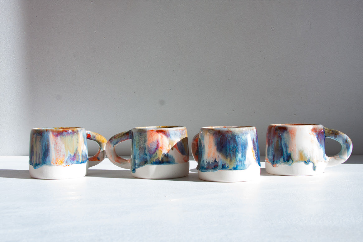 four handmade ceramic multicoloured mugs