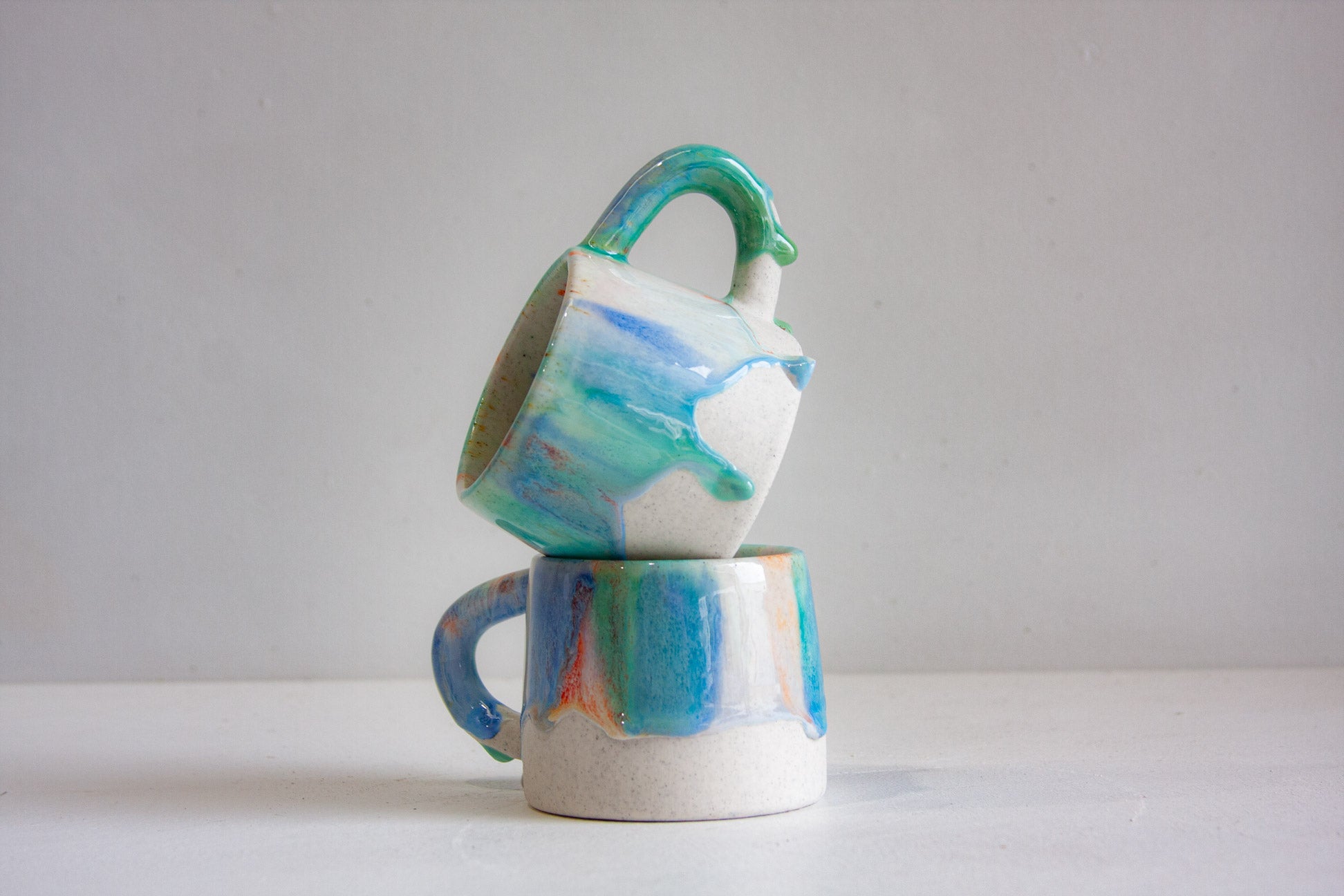 two handmade ceramic blue, green and orange drippy glazed mugs 