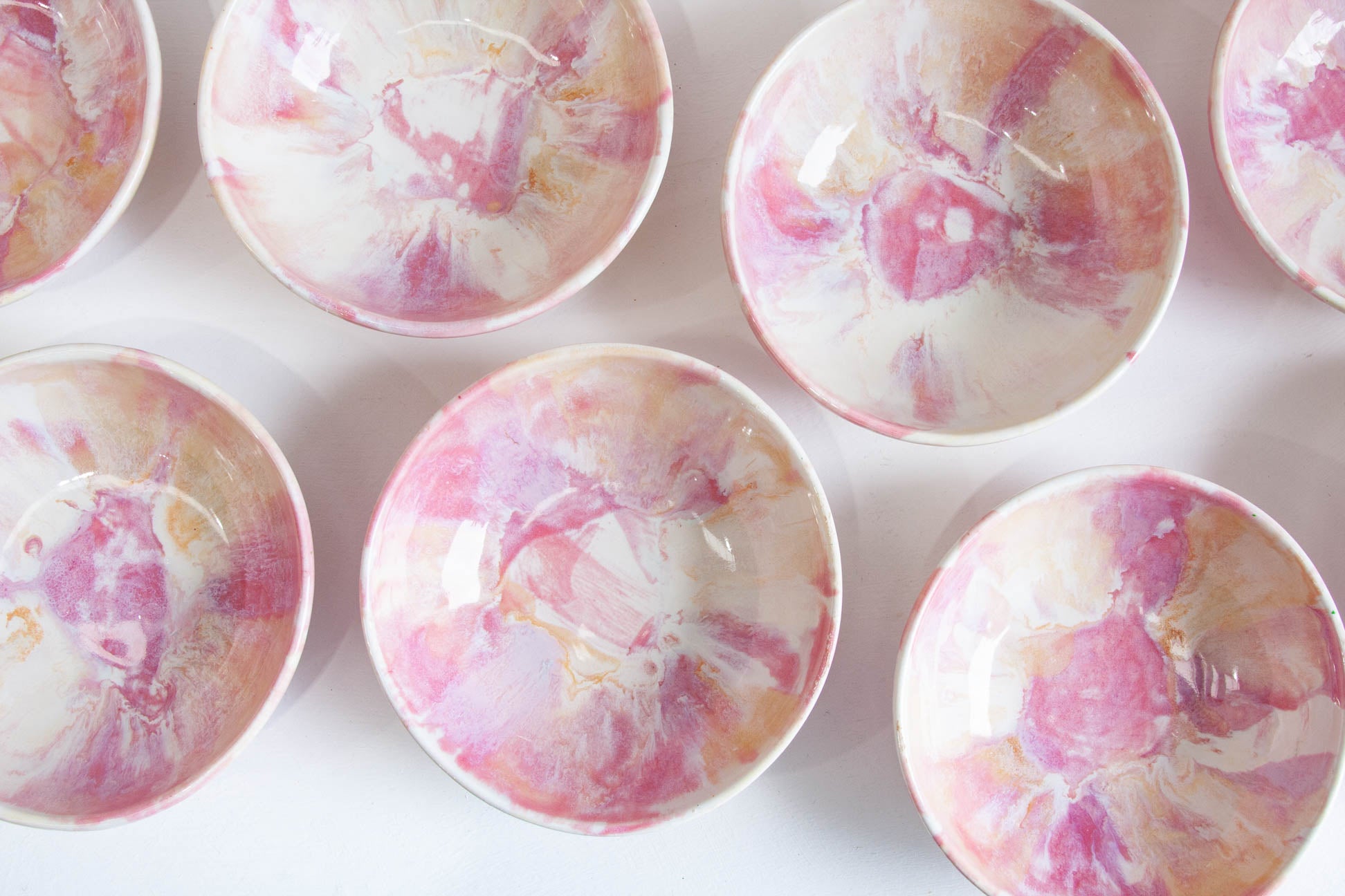 A set of small round bowls with a glossy white and pink marbled floral pattern, arranged on a clean white background.