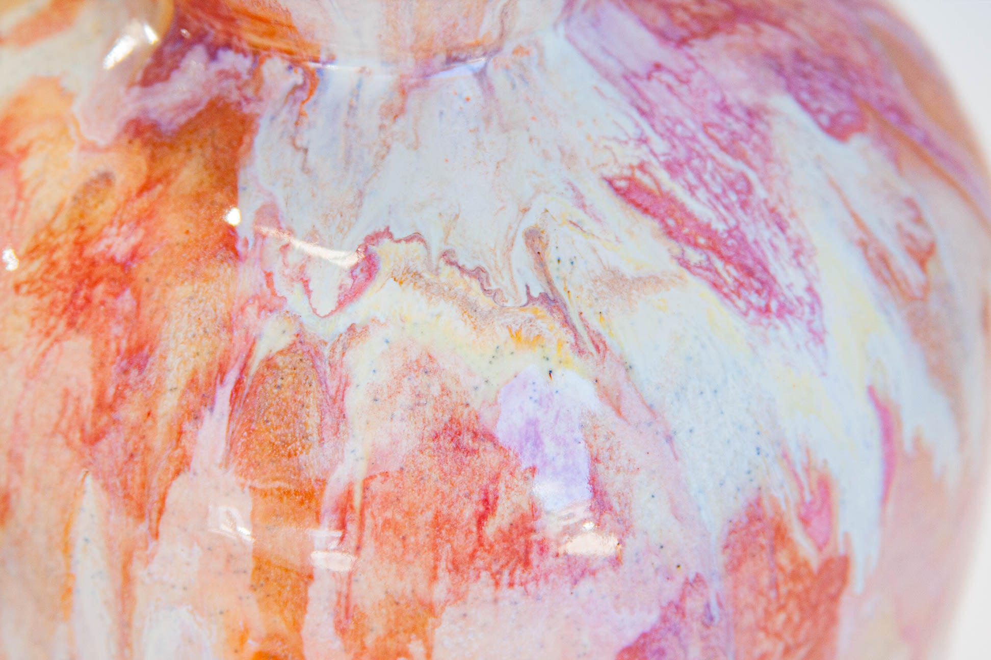 close up of cream, pink, brown glaze details on a handmade ceramic vase.