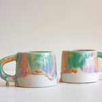 two drippy glazed handmade ceramic mugs.