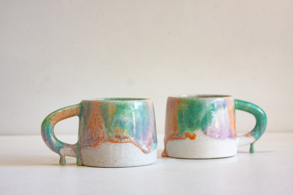 two drippy glazed handmade ceramic mugs.