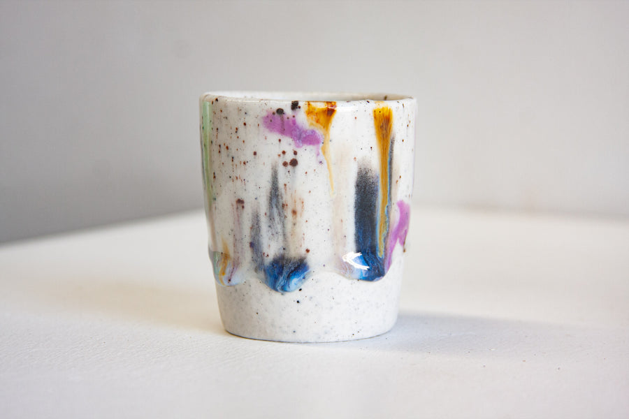 handmade ceramic espresso cup splattered in glaze colours such as blue, purple and brown
