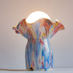 handmade ceramic table lamp shown with light on 