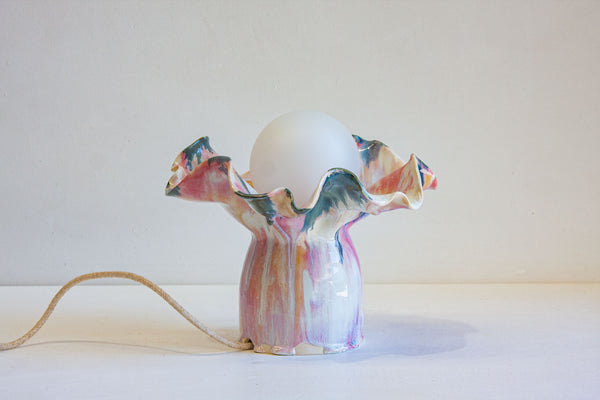 handmade ceramic table lamp glazed in a fluid drippy pink, peach and blue colour.
