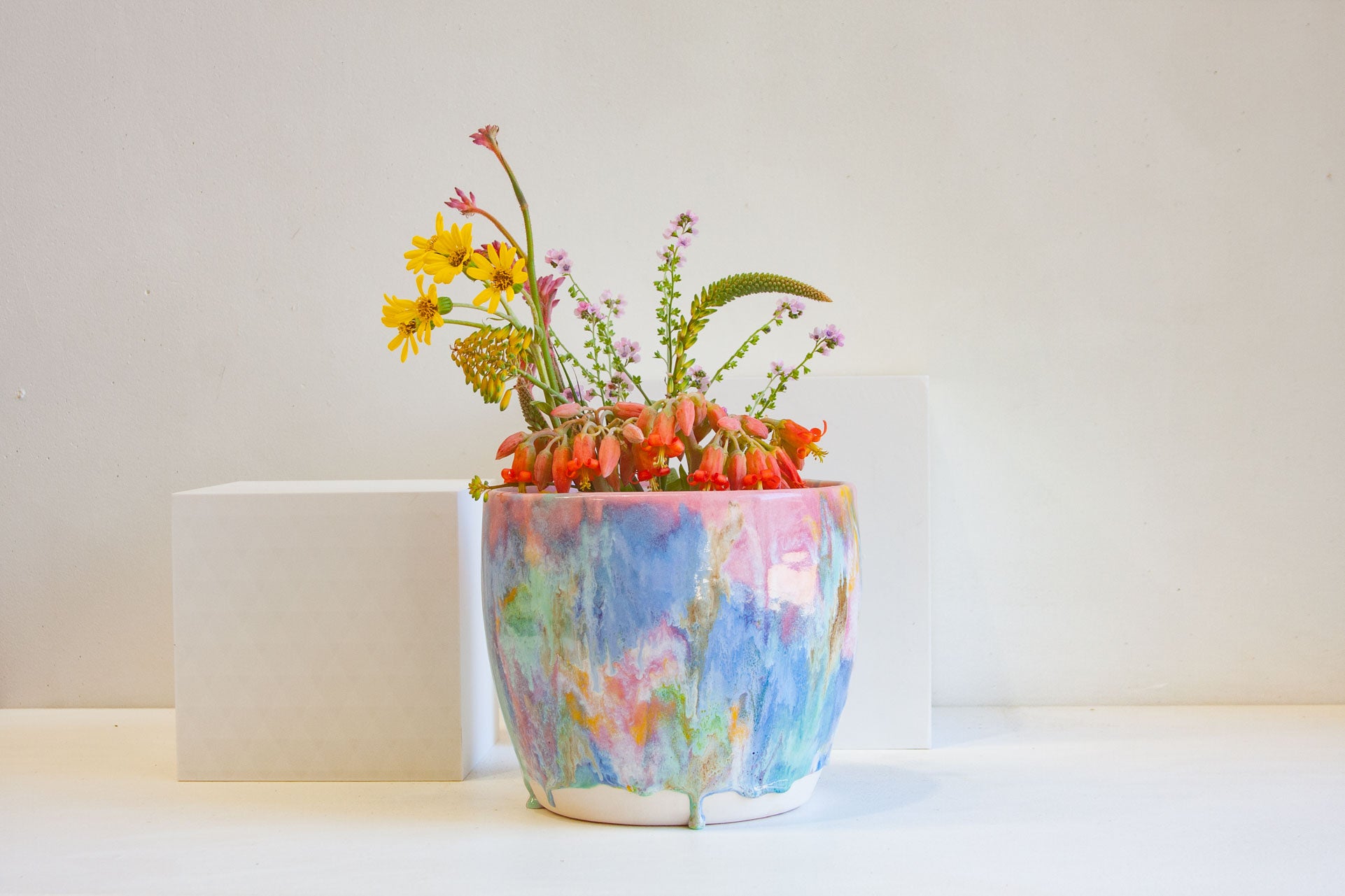 Handmade colourful watercolour planter containing a bouquet of flowers