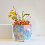 Handmade colourful watercolour planter containing a bouquet of flowers