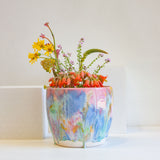 Handmade colourful watercolour planter containing a bouquet of flowers
