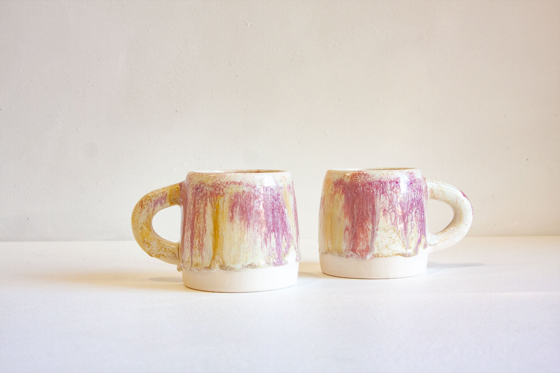 two handmade ceramic pink, brown cream mugs