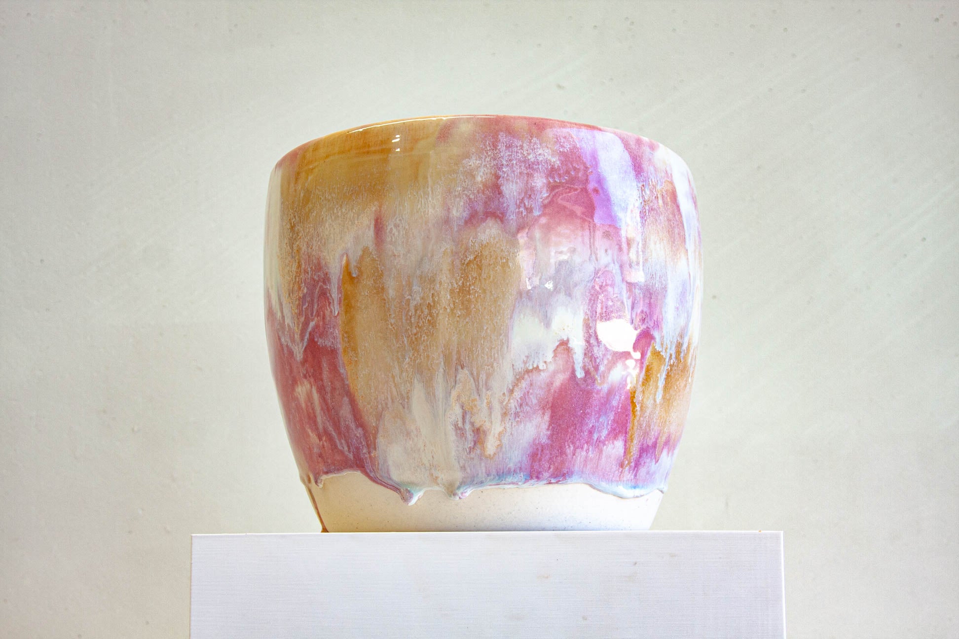 Handmade ceramic pastel pink planter shown on plinth 
