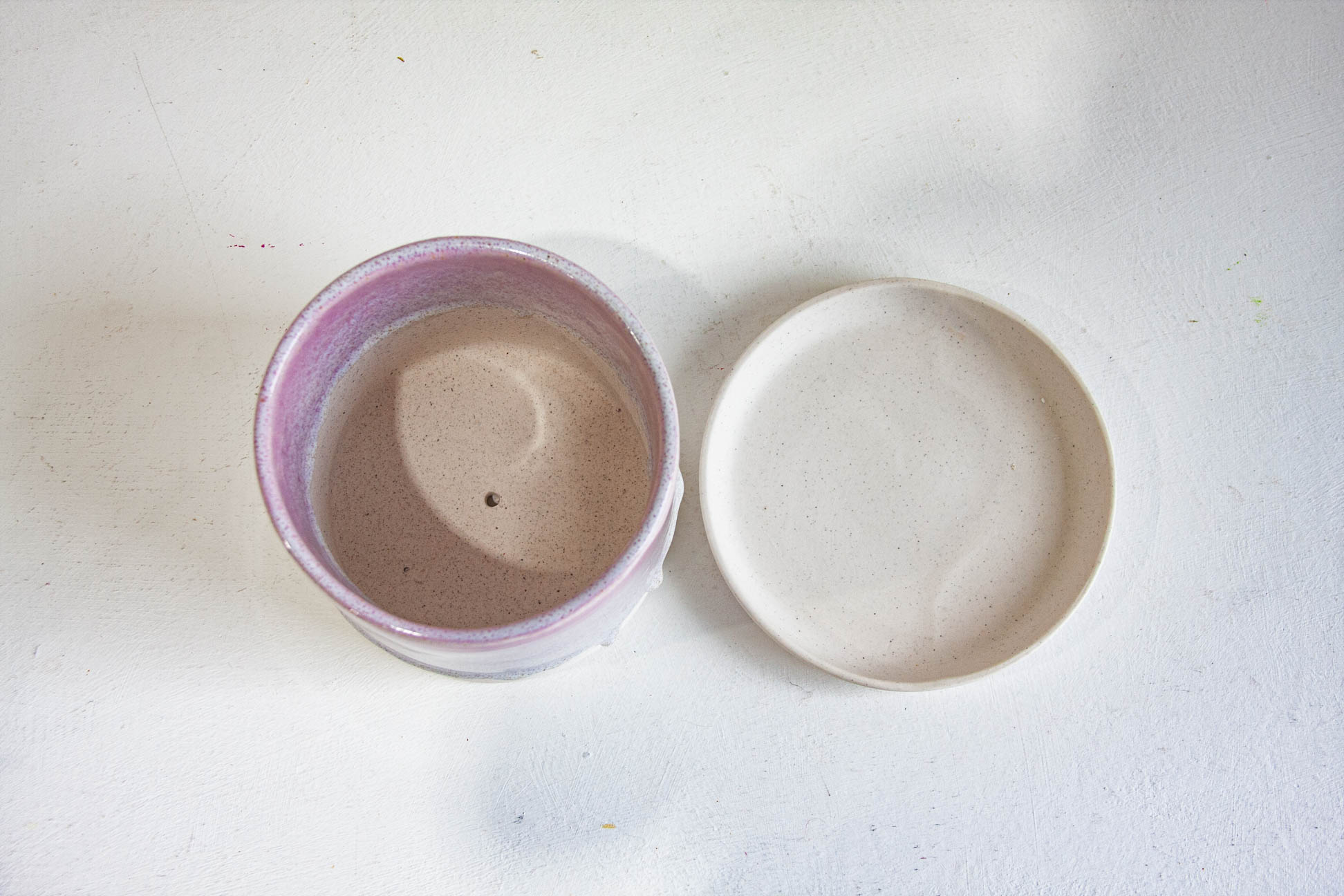 handmade ceramic saucer and planter sitting together, photo taken from above.