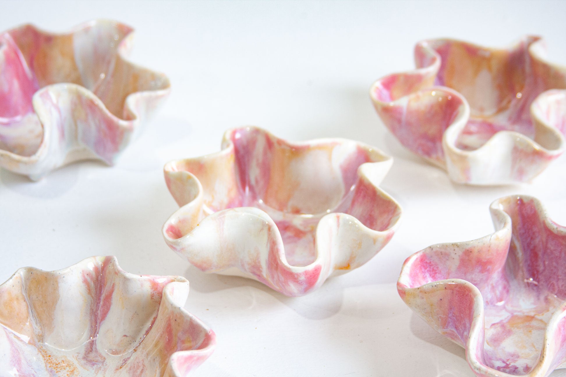 Decorative shell bowls with pink and white marbled pattern on a white background