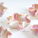 Decorative shell bowls with pink and white marbled pattern on a white background