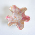 Marbled pink and orange star-shaped object on a white background