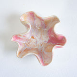 Marbled pink and orange star-shaped object on a white background