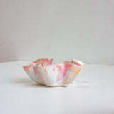Marbled pink and white ceramic bowl on a light surface with a neutral background