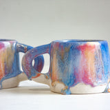 two handmade ceramic mugs glazed in pink, blue an peach