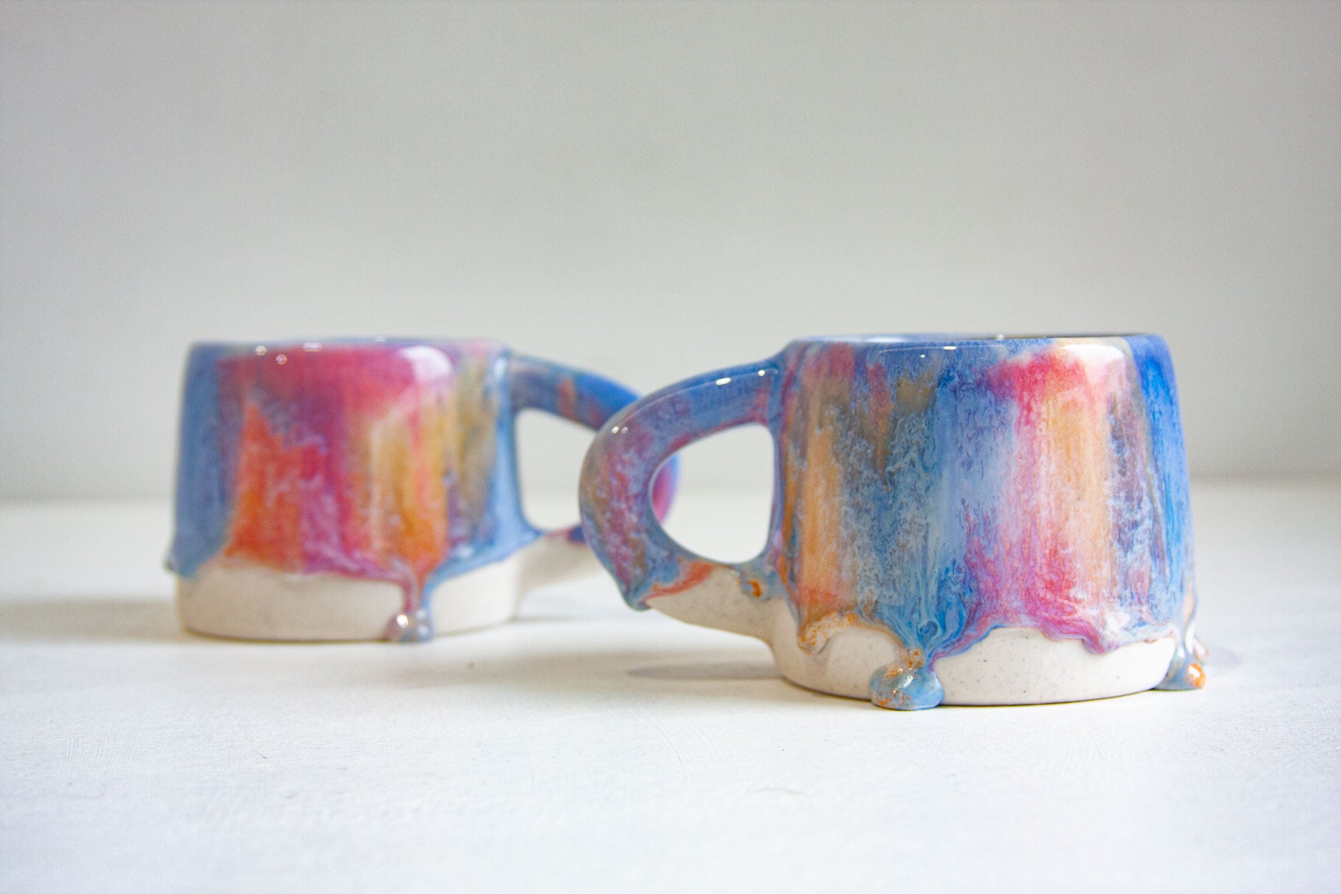 photo of two handmade ceramic drippy glaze mugs
