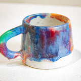 close up of blue, green, orange and pink handmade ceramic mug