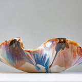 handmade ceramic oyster shaped platter glazed in blue, brown, peach and pink.