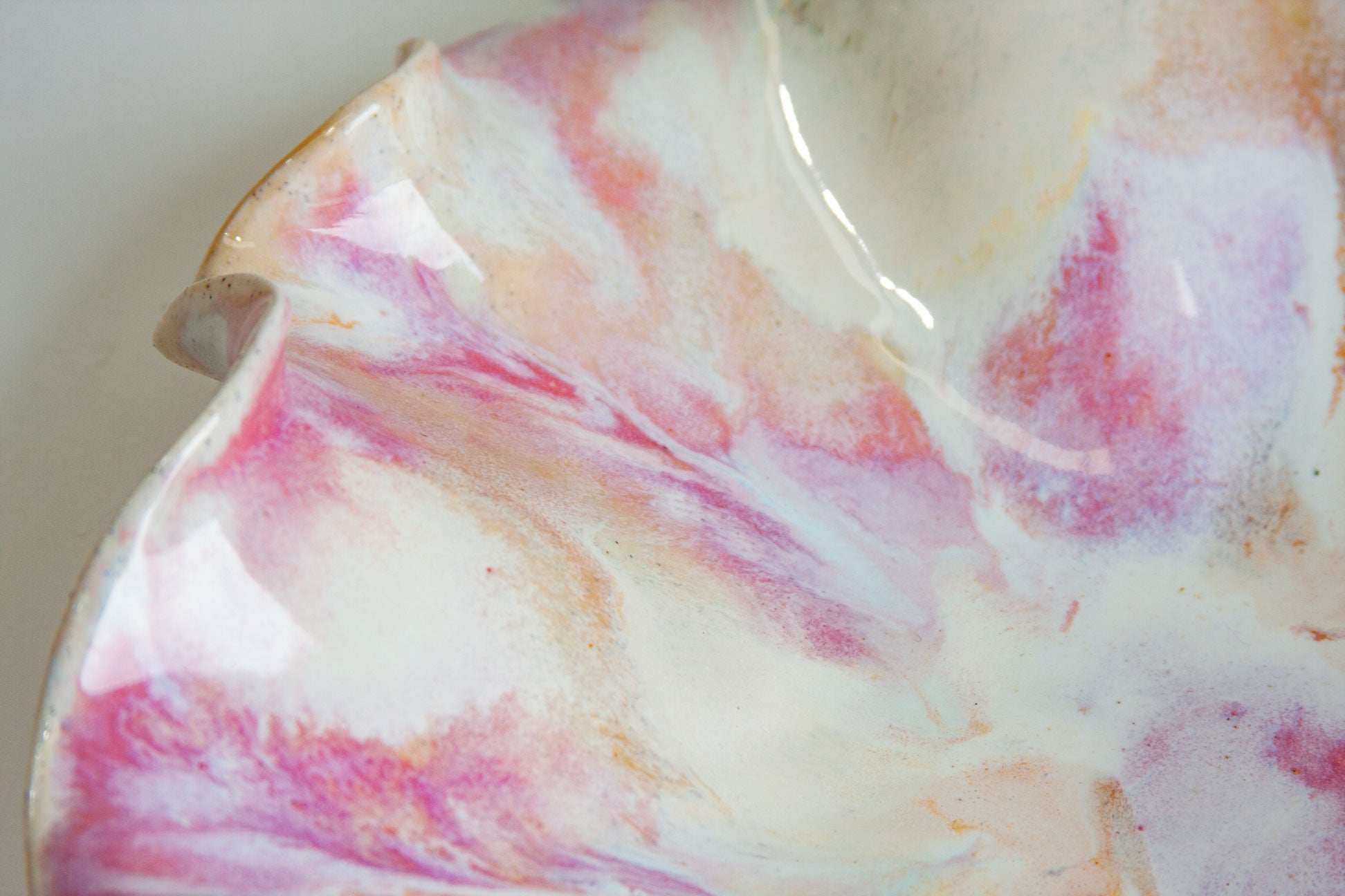 Marbled ceramic dish with pink, orange, and white colors on a white background