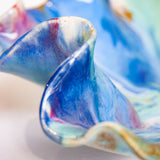 Close-up of a colourful ceramic platter with swirling patterns on a white background