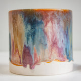 close up of pink, peach, brown and blue glazed cylindrical planter