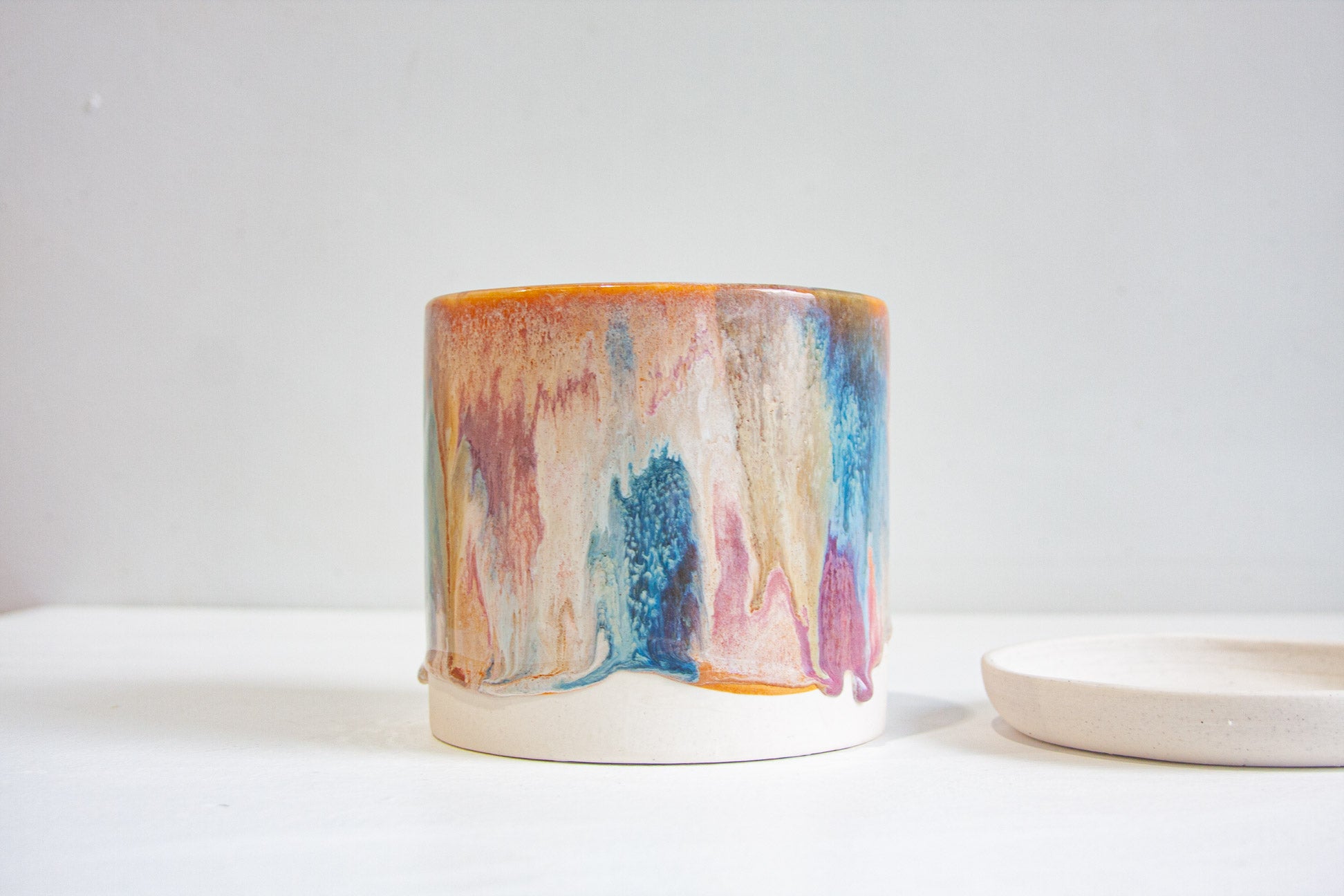 handmade ceramic planter sitting next to ceramic saucer on table