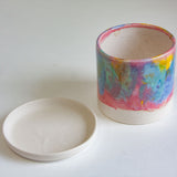 handmade ceramic rainbow planter sitting beside a ceramic saucer dish