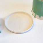 two drippy glazed green planters beside one unglazed ceramic drip tray.